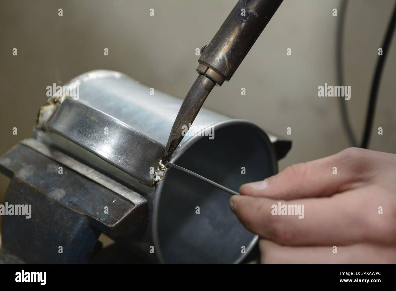 Saldatura con filo di saldatura su una lattina di stagno - primo piano Foto Stock