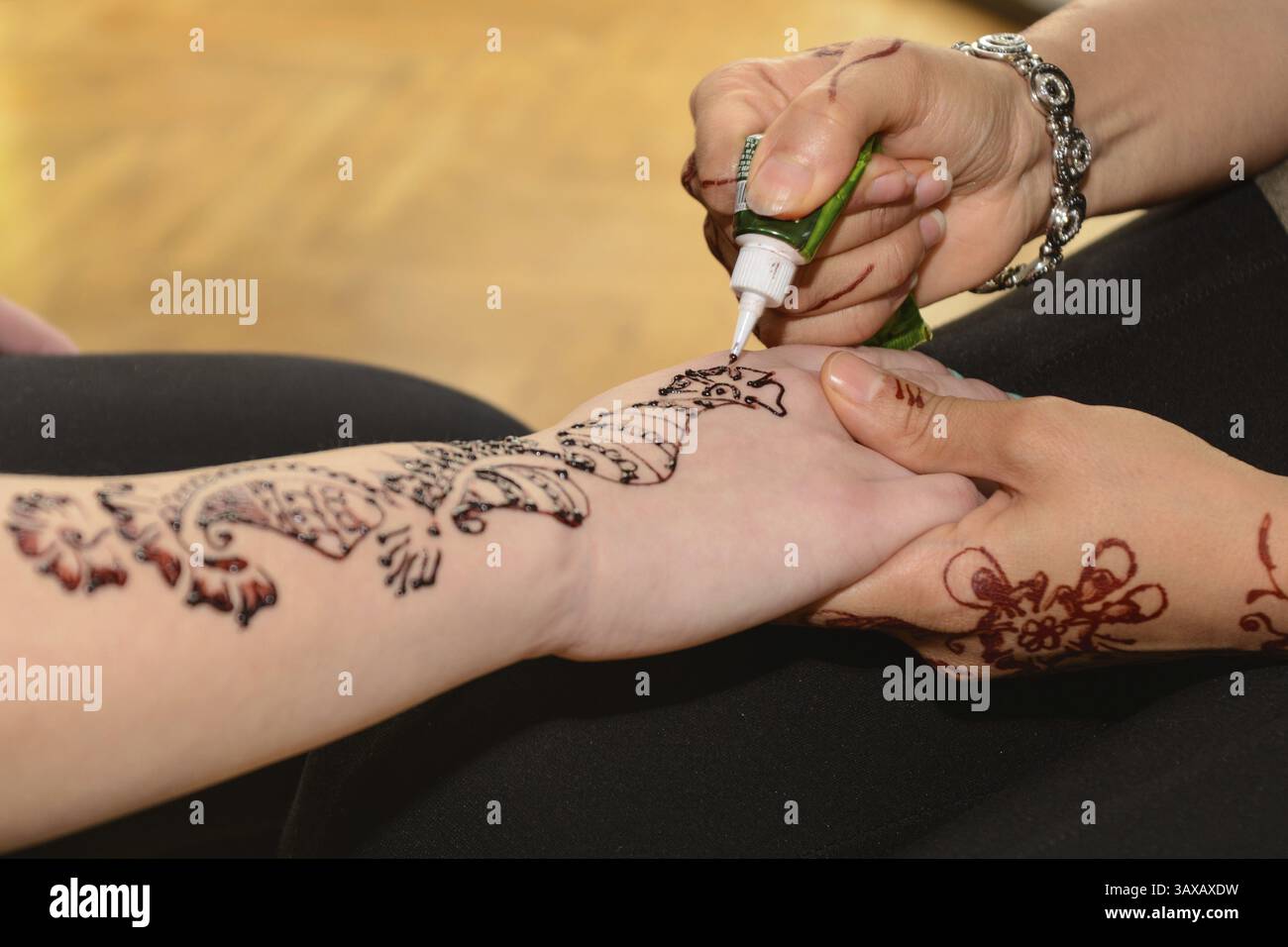 La persona fa tatuaggi all'henné sulle mani - primo piano Foto Stock