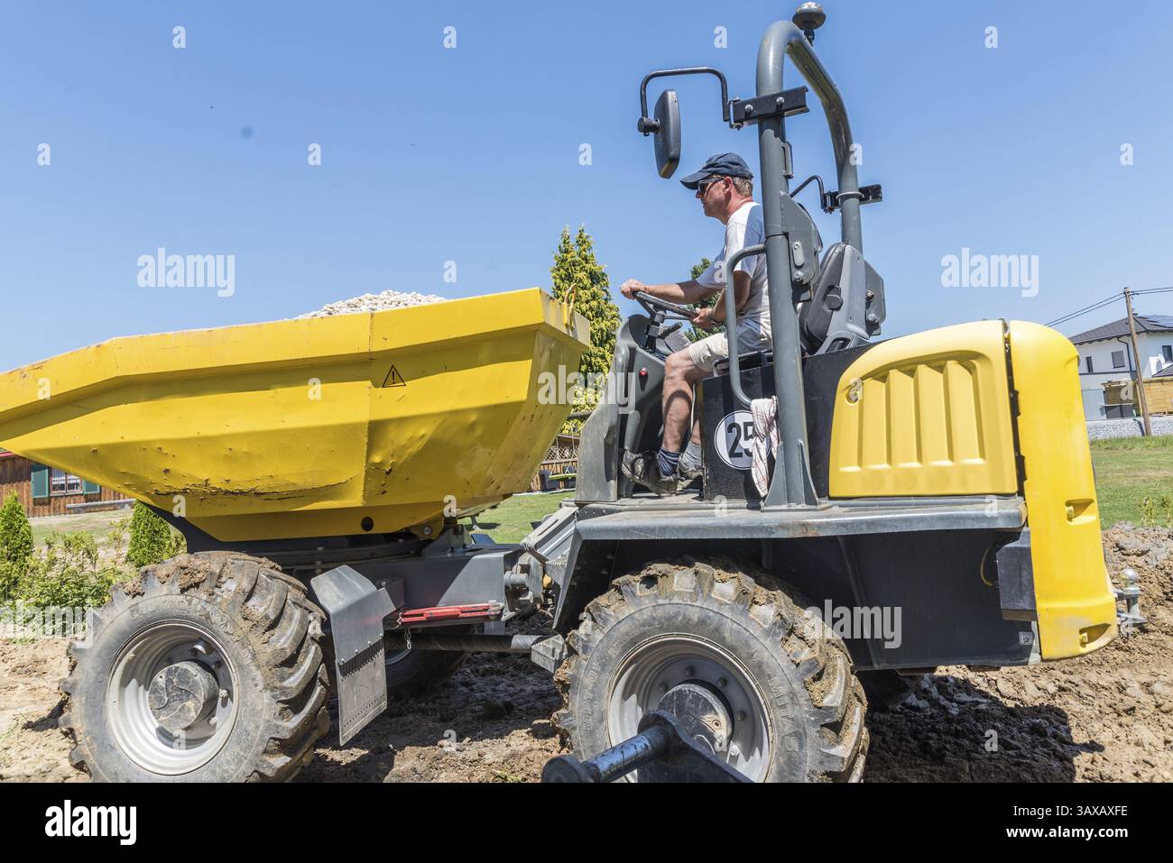 L'operaio edile guida in cantiere con dumper - veicolo da costruzione per movimento terra, industria edile Foto Stock