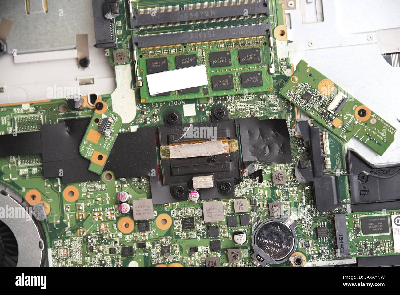 Laptop aperto con scheda madre e numerosi giunti saldati, batteria, ventola - hardware Foto Stock