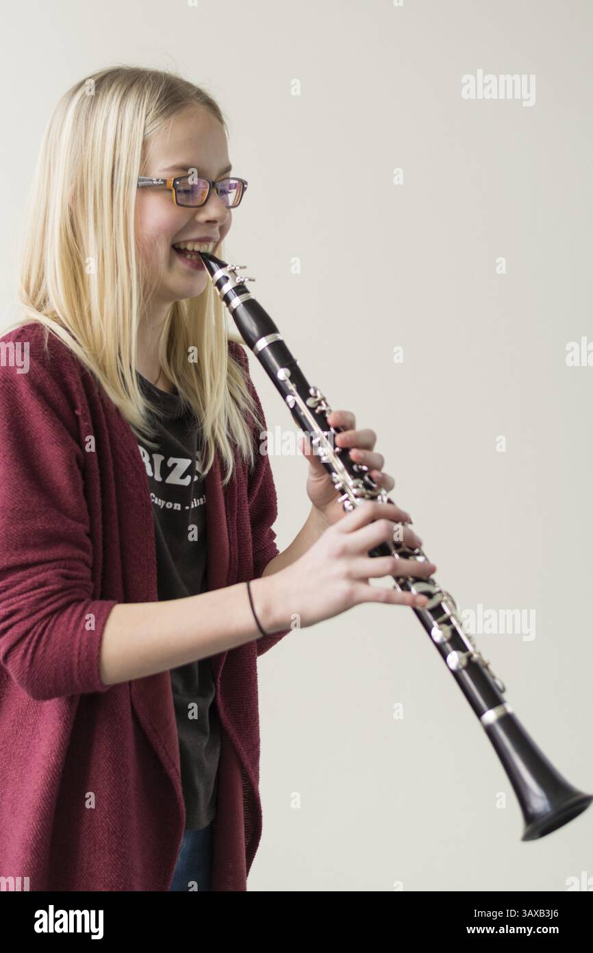 L'adolescente inizia a ridere mentre suona il clarinetto Foto Stock