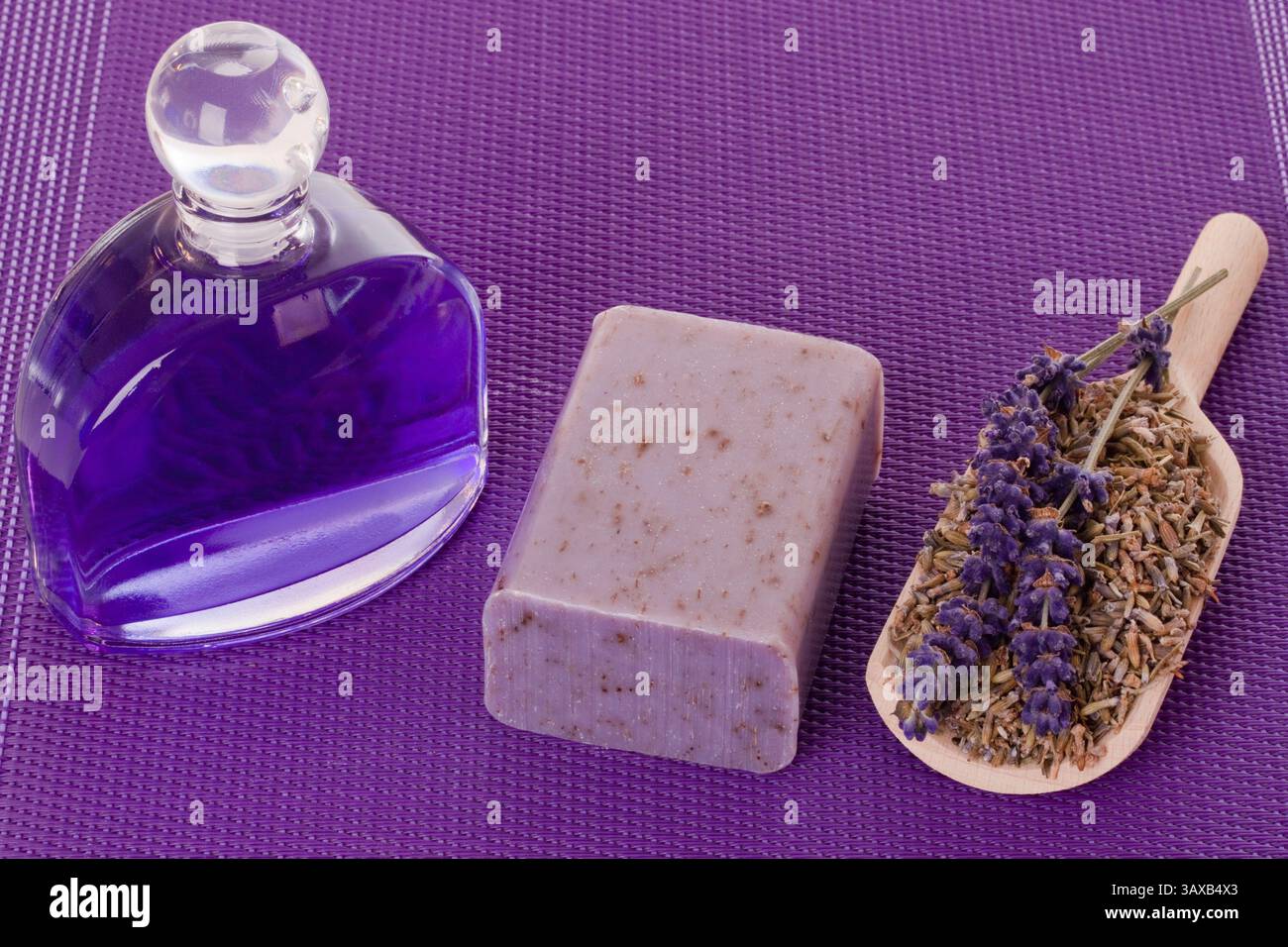 Essenza da bagno e sapone con lavanda su fondo viola essenza da bagno e sapone con lavanda su fondo viola Foto Stock