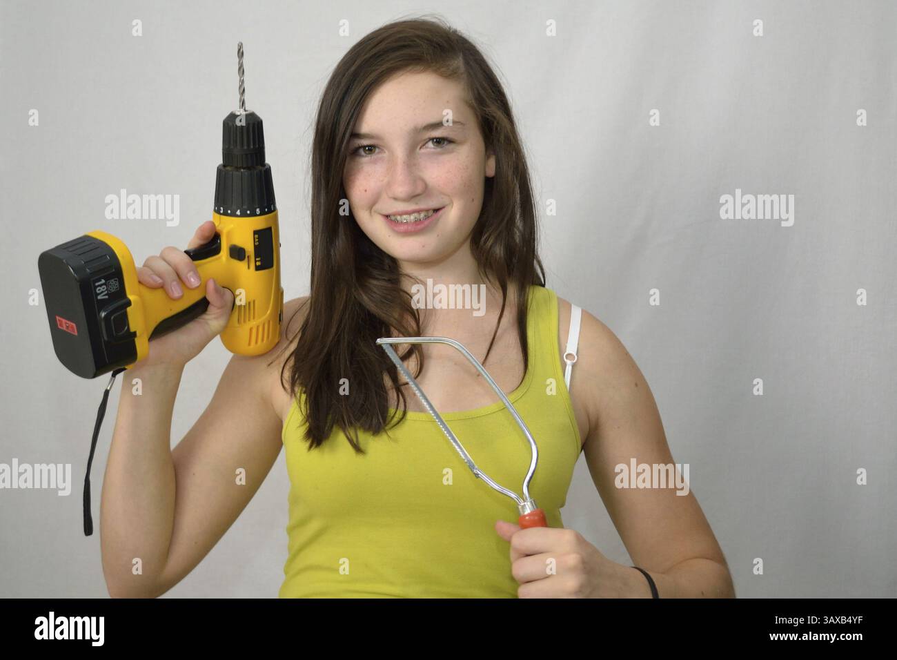Giovani con cacciaviti a batteria e seghetti Foto Stock