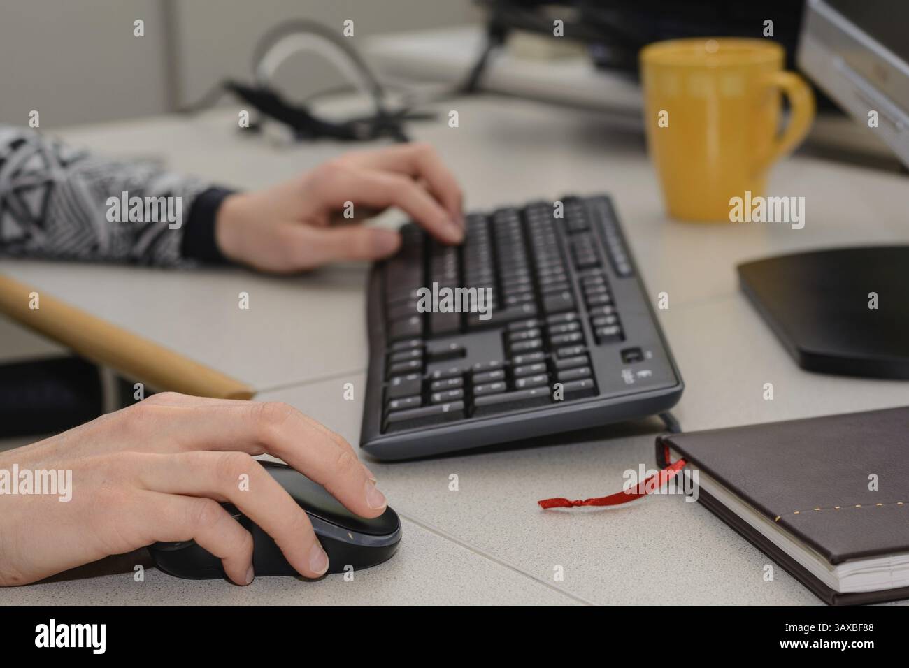 Lavoratore in ufficio che lavora con tastiera e mouse - postazione di lavoro da vicino Foto Stock
