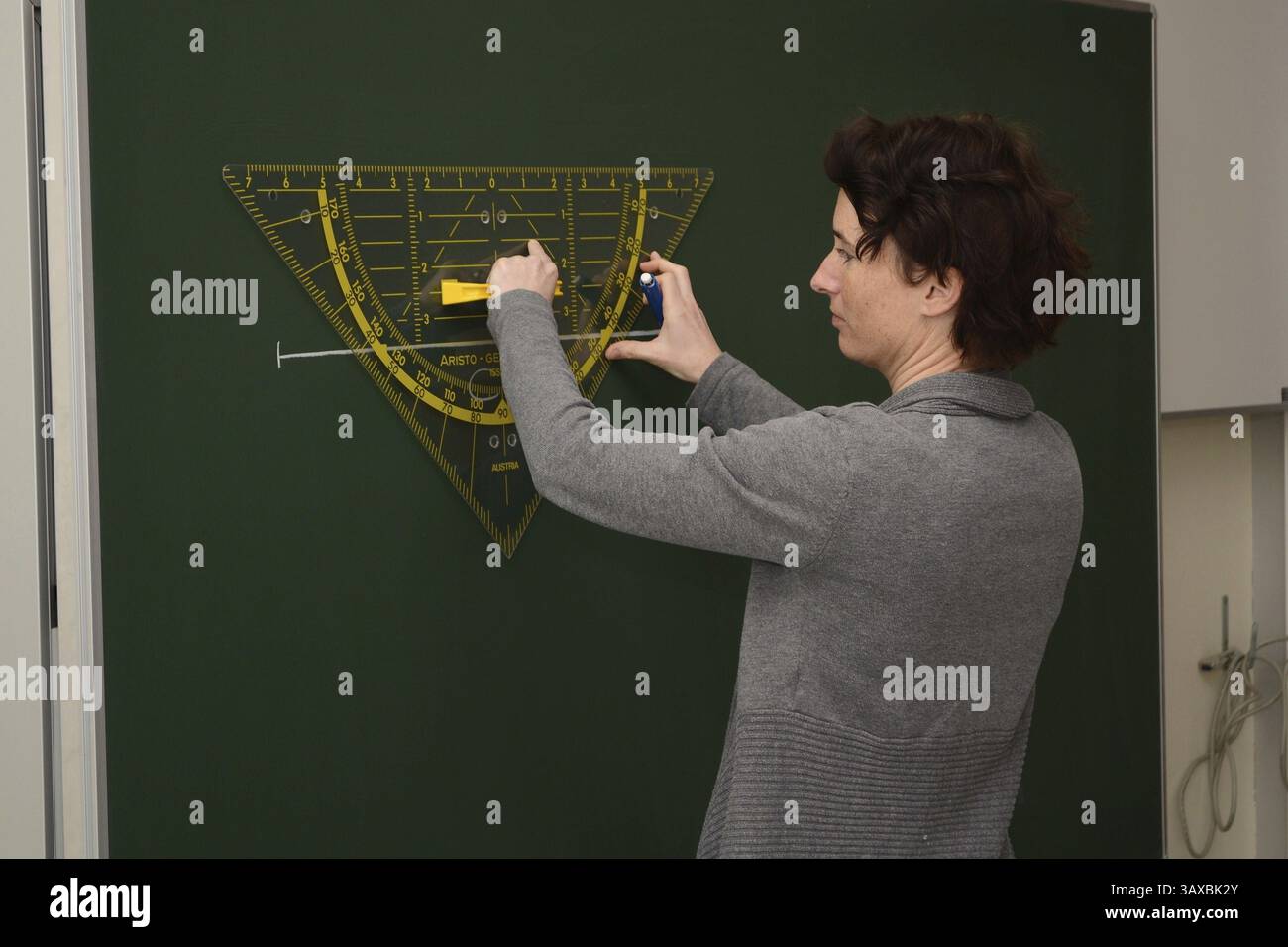 L'insegnante disegna con un goniometro sulla lavagna Foto Stock