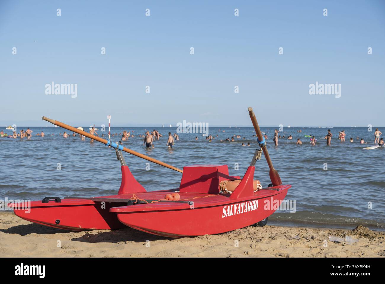 Barca a remi rossa sulla spiaggia sabbiosa di una località balneare italiana Foto Stock