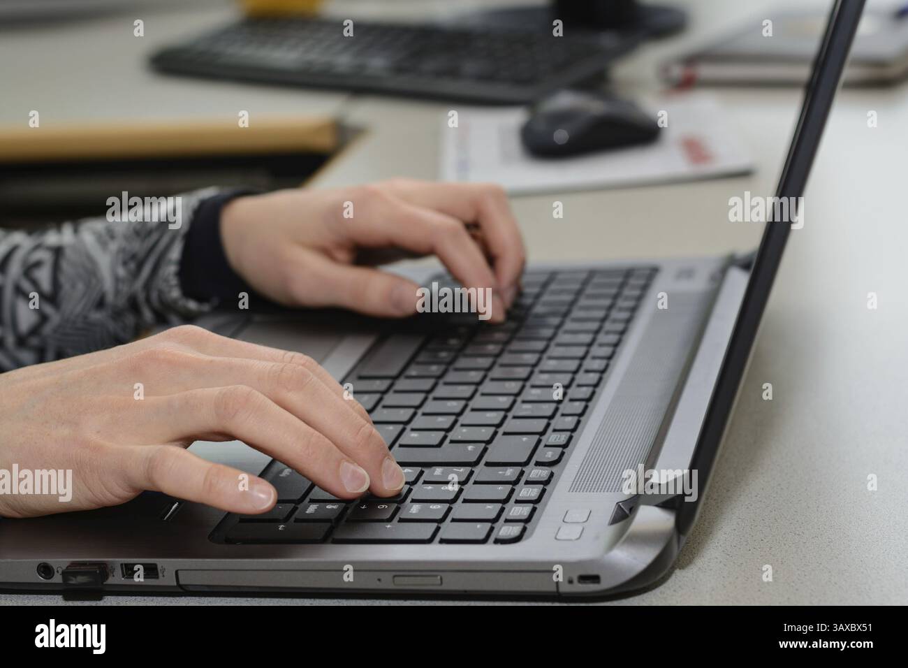Impiegato che lavora su un laptop - primo piano Foto Stock