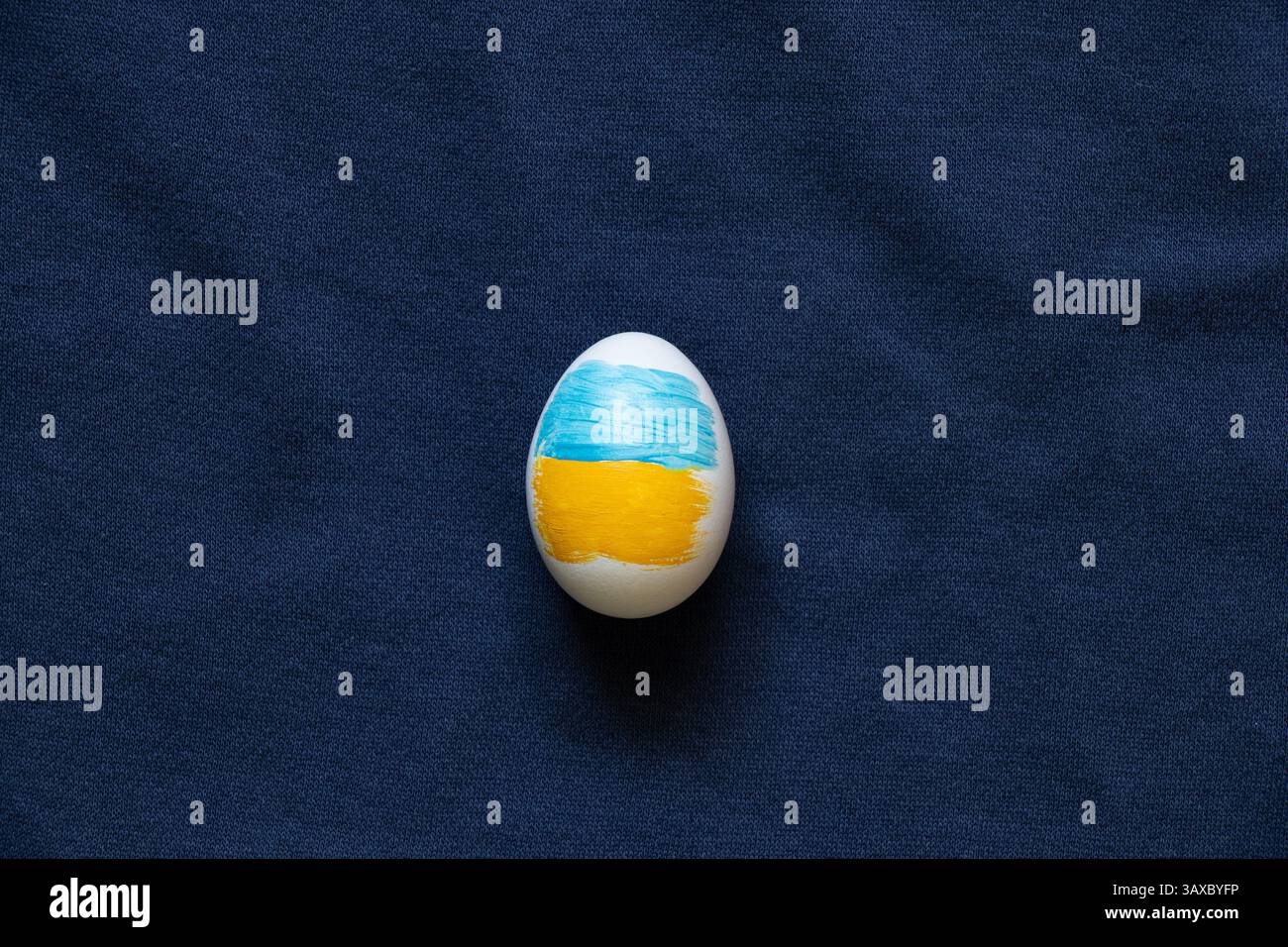 Uovo di Pasqua dipinto nei colori della bandiera Ucraina su sfondo blu, Pasqua in Ucraina Foto Stock