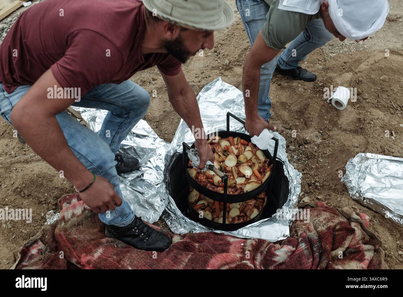 22 febbraio 2017 - Israele - Un pasto viene cucinato in una buca nel terreno in modo tradizionale beduino chiamato "zarb". Un'esperienza di ospitalità beduina è fornita da Sahari, un'organizzazione no-profit di recente costituzione registrata sotto l'Autorità palestinese, che mira a fornire servizi turistici nel deserto e reddito diretto per migliorare le condizioni di vita della comunità Jahalin. Circa 6.000 beduini della Cisgiordania Jahalin affrontano un futuro incerto sotto la minaccia di sfratto dalla terra che vagano tra Gerusalemme Est e la Valle del Giordano, per essere reinsediati a nord di Gerico. (Immagine di credito: © Nir Alon Foto Stock