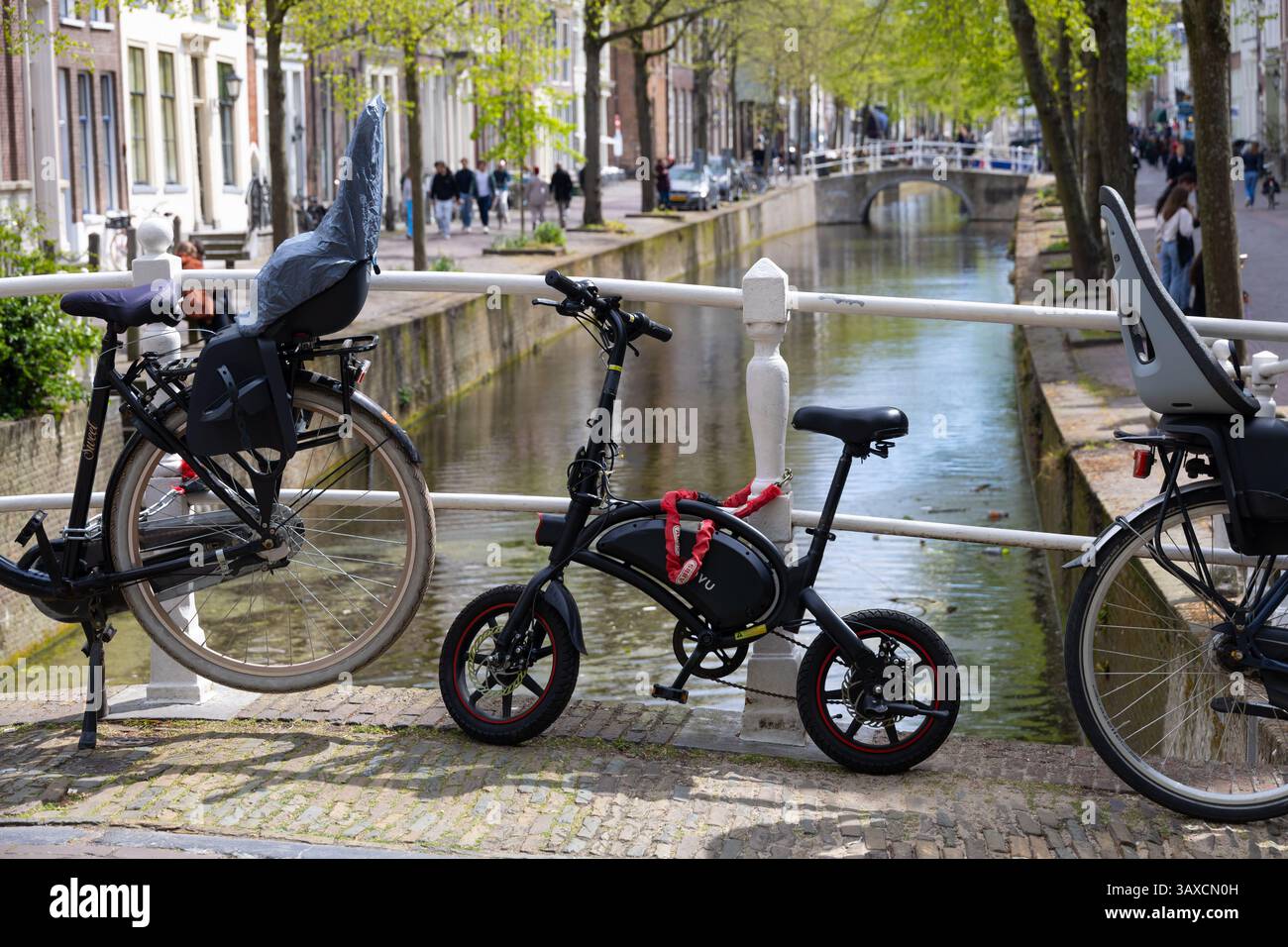 Delft, Paesi Bassi - 19 aprile 2025: Piccola bici pieghevole parcheggiata sul panoramico canale di delft Foto Stock