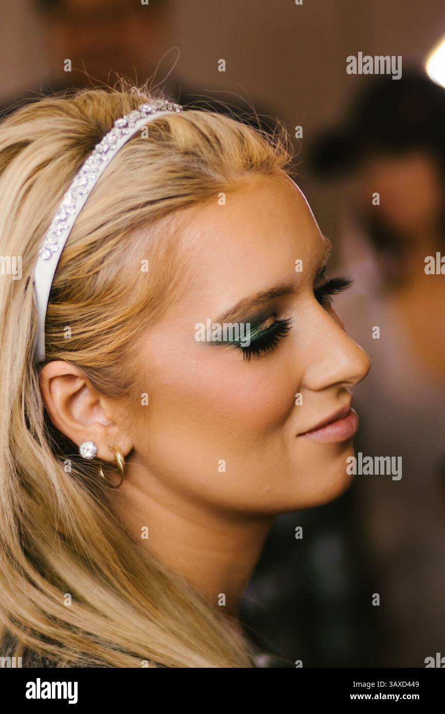 Donna bionda in salone con ciglia e sorrisi di trucco Foto Stock