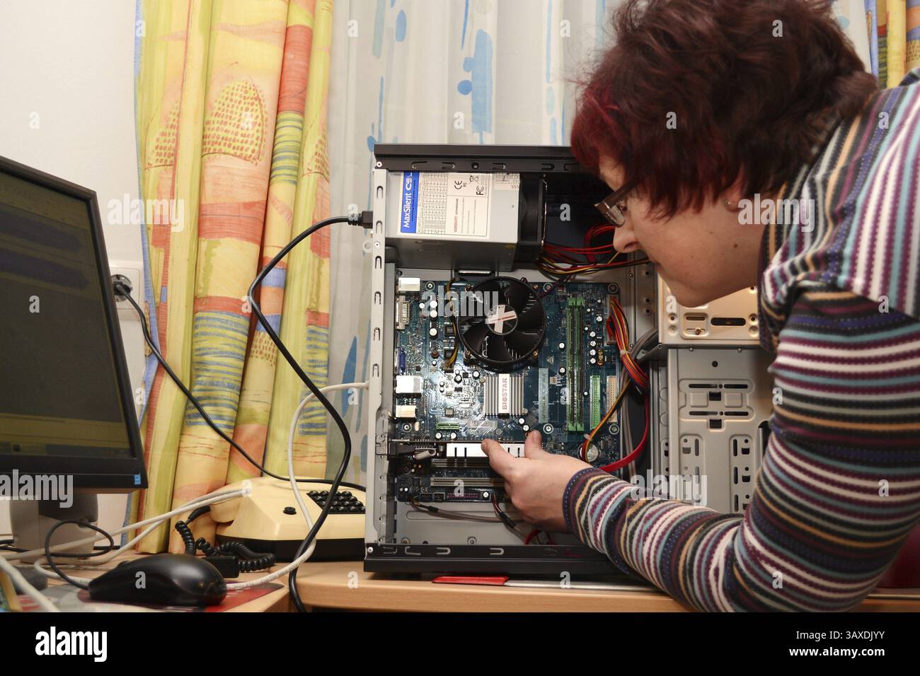 Il tecnico di rete installa la scheda grafica nel PC Foto Stock