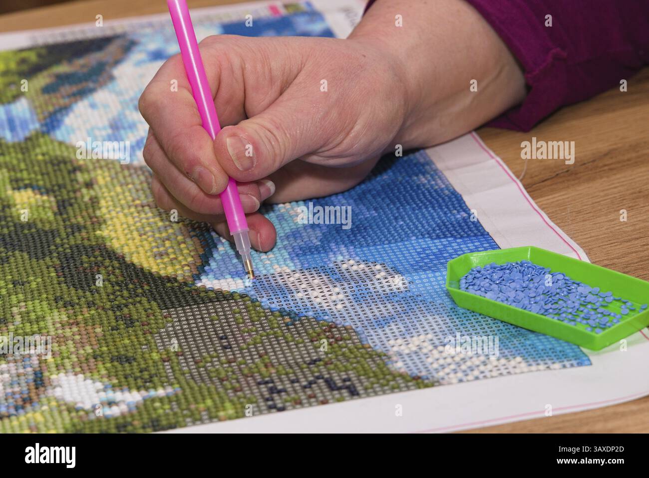 La persona crea un quadro colorato con la pittura a diamanti - primo piano Foto Stock