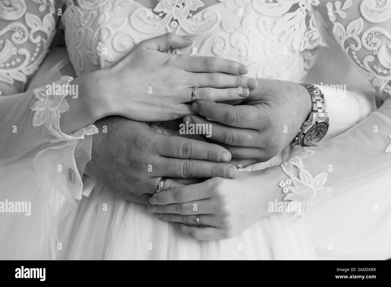Intimo momento di matrimonio: Mani interchiuse con anelli che simboleggiano l'amore e l'impegno in un Ritratto bianco e nero. Foto Stock