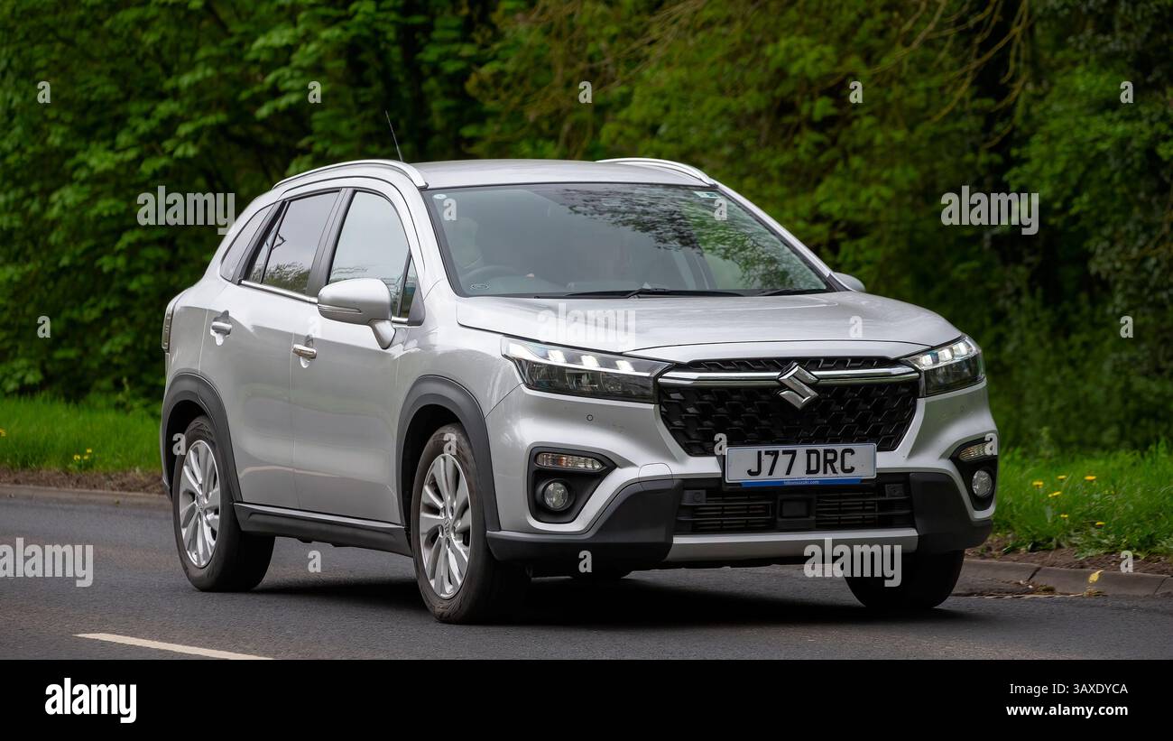 Milton Keynes, Regno Unito - 9 aprile 2025: 2023 Suzuki SX4 S-cross Motion B-JET Mhev auto elettrica ibrida che guida su una strada di campagna britannica Foto Stock