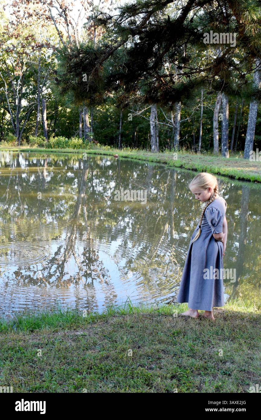 27 settembre 2016 - Cuba, Missouri, Stati Uniti - ci sono molti momenti di riflessione e quiete inchiesta osservati nella vita di Zimmerman. Krixana, distratta dal gioco per un momento, si trova vicino al lago colto nel pensiero. Gli Zimmerman vivono secondo la loro fede mennonita con intenzione seguendo la parola di Dio. (Immagine di credito: © Andriana Mereuta via ZUMA Wire) Foto Stock