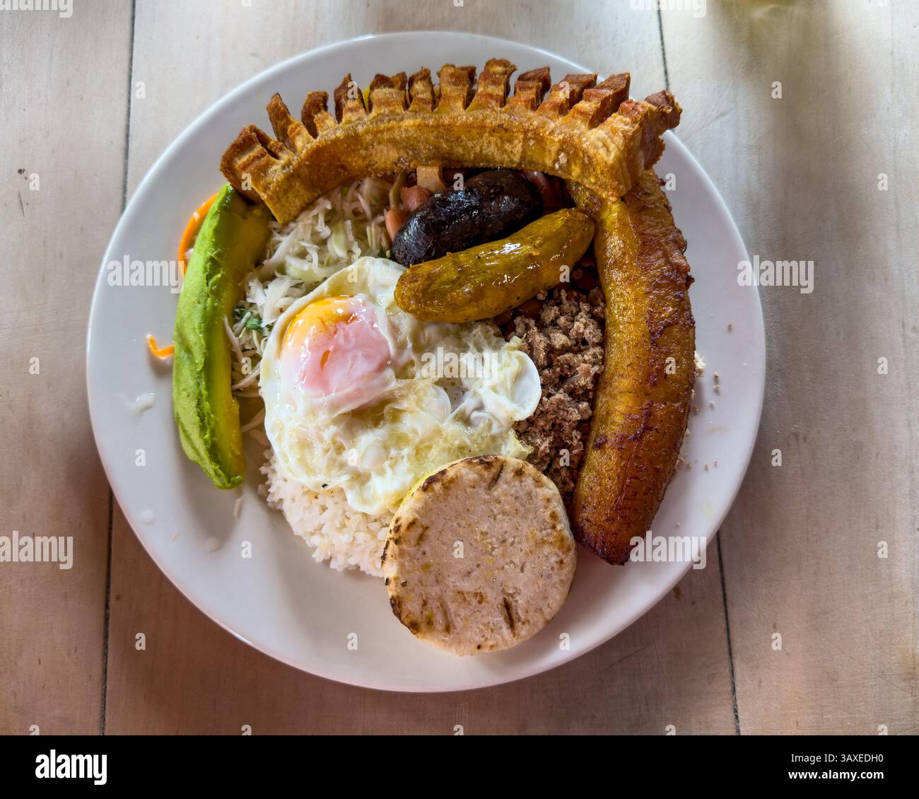 Un tradizionale Bandeja Paisa o piatto colombiano in un ristorante sulla strada in Colombia. Fagioli, riso, carne macinata, salsiccia di maiale, salsiccia di sangue, por fritto Foto Stock