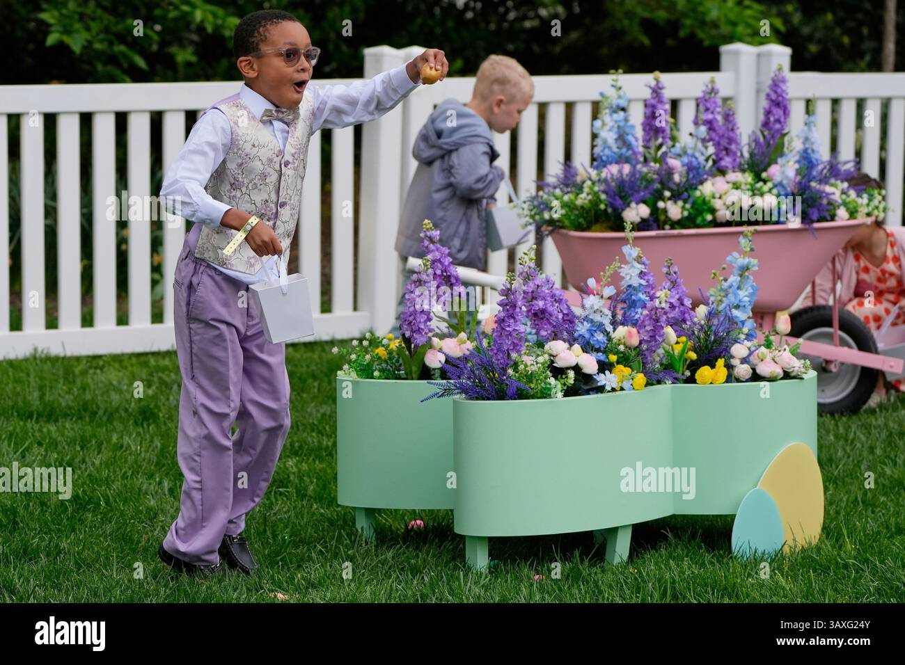 Children participate in an egg hunt on the South Lawn of the White House before President Donald Trump and first lady Melania Trump participate in the White House Easter Egg Roll Monday, April 21, 2025, in Washington. (AP Photo/Alex Brandon) Foto Stock