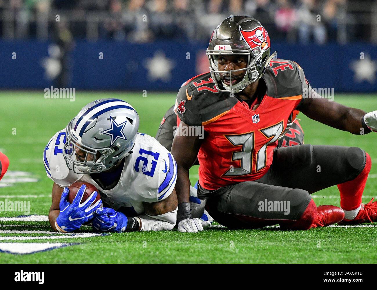 18 dicembre 2016: Il running back dei Dallas Cowboys Ezekiel Elliott (21) riceve un passaggio mentre viene placcato dalla strong safety dei Tampa Bay Buccaneers Keith Tandy (37) durante una partita di football tra i Tampa Bay Buccaneers e i Dallas Cowboys la domenica sera all'AT&T Stadium di Arlington, Texas. . Manny Flores/CSM Foto Stock