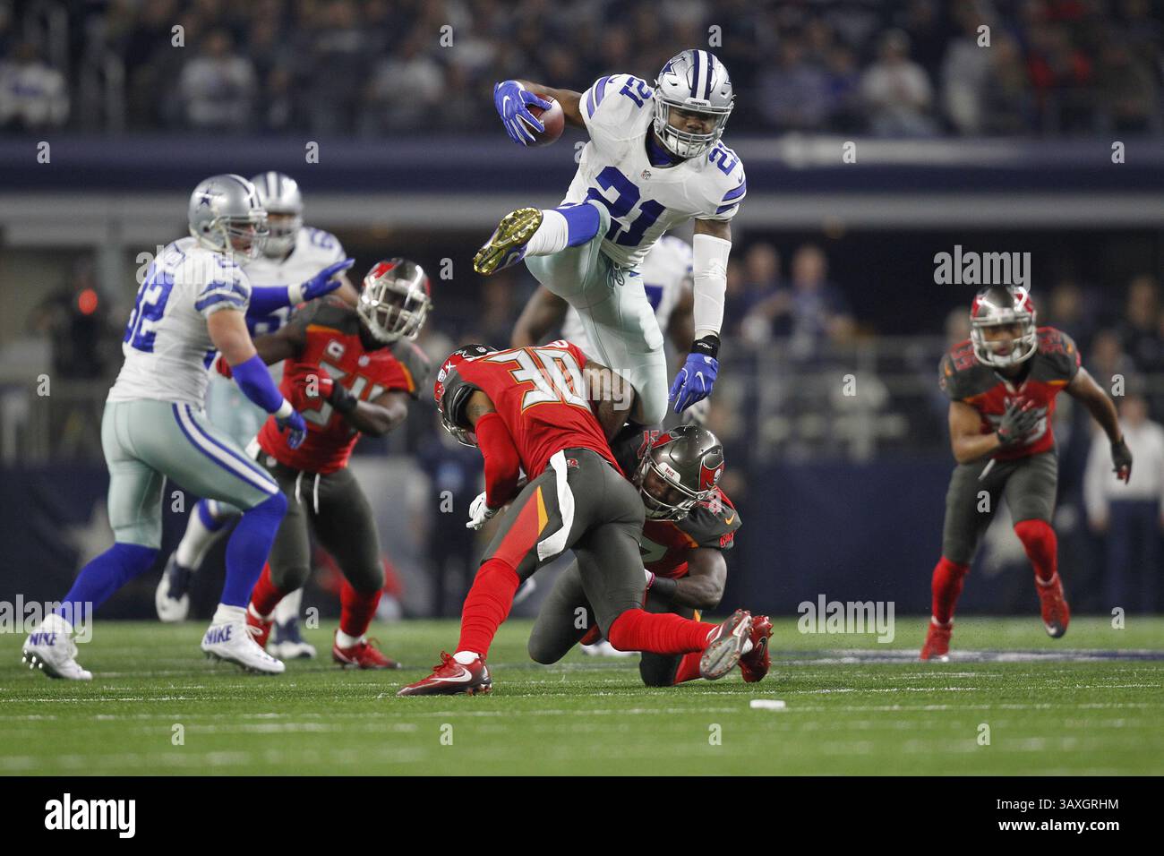 18 dicembre 2016 - Arlington, Texas, USA - il running back dei Dallas Cowboys Ezekiel Elliott (21) salta sopra la safety gratuita dei difensori di Tampa Bay Bradley McDougald (30) e la strong safety Keith Tandy (37) nel primo quarto di domenica 18 dicembre 2016 all'AT&T Stadium di Arlington, Texas. (Immagine di credito: © Khampha Bouaphanh/TNS via ZUMA Wire) Foto Stock