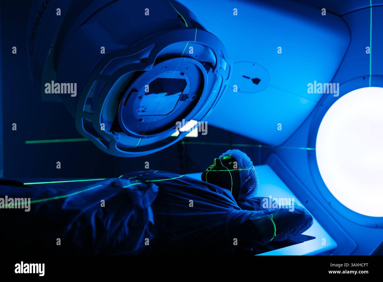 Un giovane sottoposto a radioterapia per il cancro in una clinica oncologica all'avanguardia che utilizza un acceleratore lineare. Foto Stock