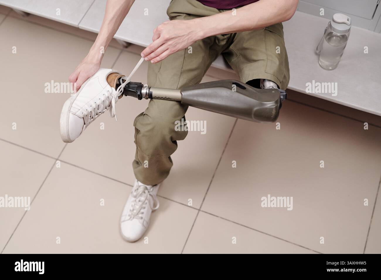 Uomo con gamba robotica che indossa scarpe sportive mentre si prepara all'allenamento Foto Stock