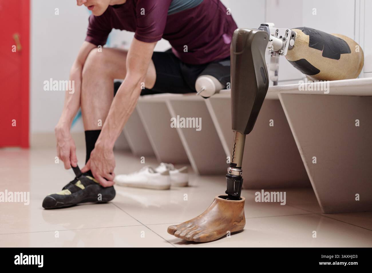 Gamba robotizzata sul banco contro l'uomo disabile che indossa scarpe protettive Foto Stock