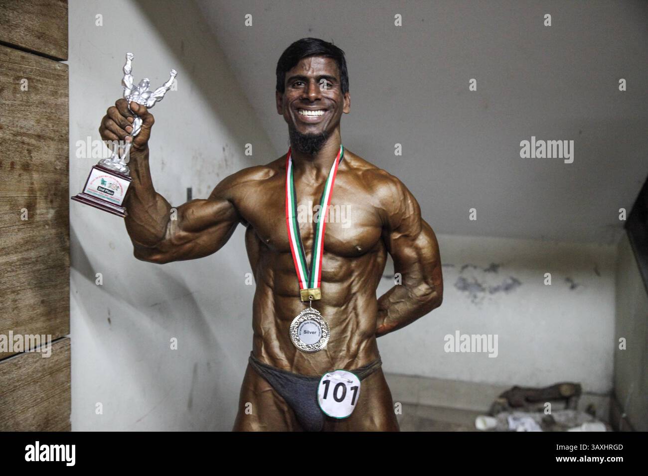 29 dicembre 2016 - Dacca, Bangladesh - Un bodybuilder si presenta con il suo trofeo vincente nella competizione "Mr. Bangladesh" della Bangladesh Bodybuilding Federation. (Immagine di credito: © Mushfiqul Alam via ZUMA Wire) Foto Stock