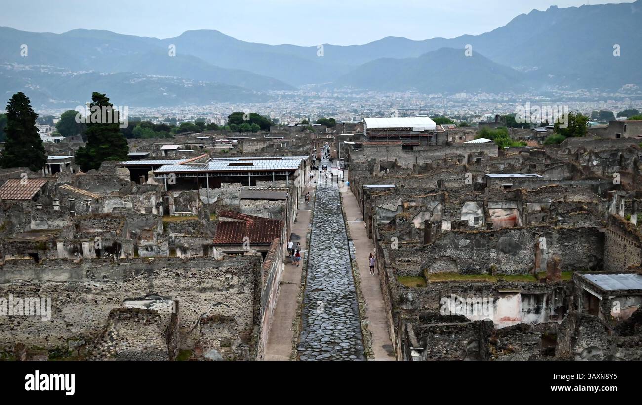 Le rovine di Pompei, con le loro mura intemprate, racchiudono innumerevoli storie. Sentieri acciottolati e vecchi edifici sussurrano storie di gloria passata. Nel dist Foto Stock