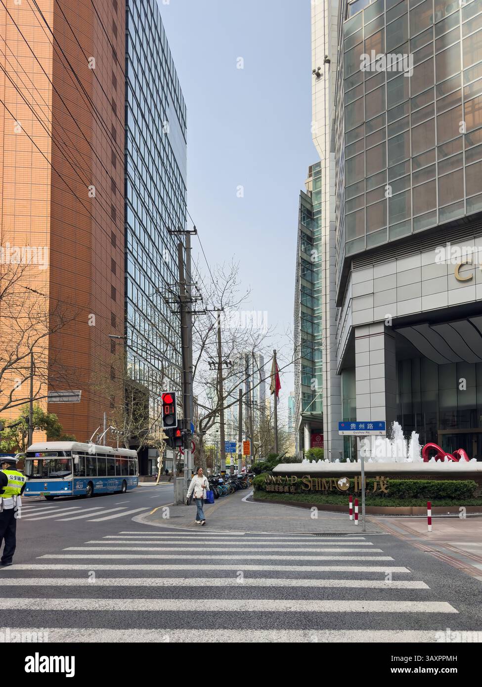 31 marzo 2025. Cina. Shanghai. Strada con attraversamenti pedonali e semaforo rosso nel centro città. Alti edifici. Foto Stock