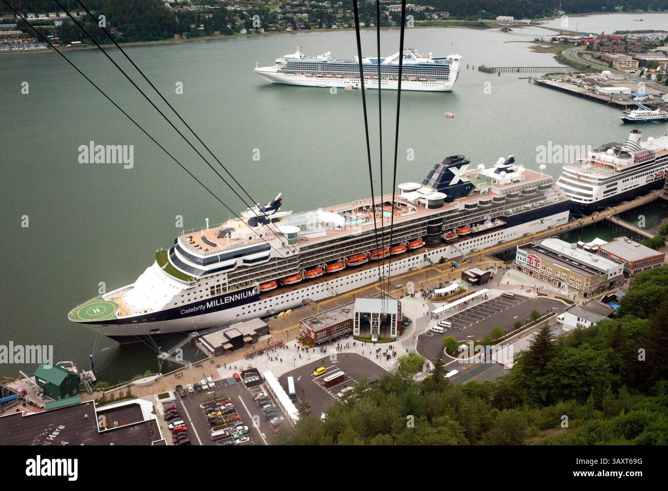 30 giugno 2016 - Juneau, Alaska, Stati Uniti - funivia del Monte Roberts al molo di Juneau, Alaska, Stati Uniti. Centro di Juneau, città. Alaska. STATI UNITI. Celebrity Millennium, nave da crociera ormeggiata tra montagne innevate e la funivia del Monte Roberts al molo di Juneau, Alaska, Stati Uniti. Terminal delle navi da crociera e funivia del monte Roberts, Alaska, Inside Passage, Stati Uniti d'America. La funivia di Mount Roberts è una funivia aerea situata appena a sud del centro di Juneau, nello stato dell'Alaska. In funzione dal 1996, il tram effettua una salita di sei minuti a Mount Roberts da 3.819 piedi (1.164 m) dai moli delle navi da crociera (solo piedi a Foto Stock