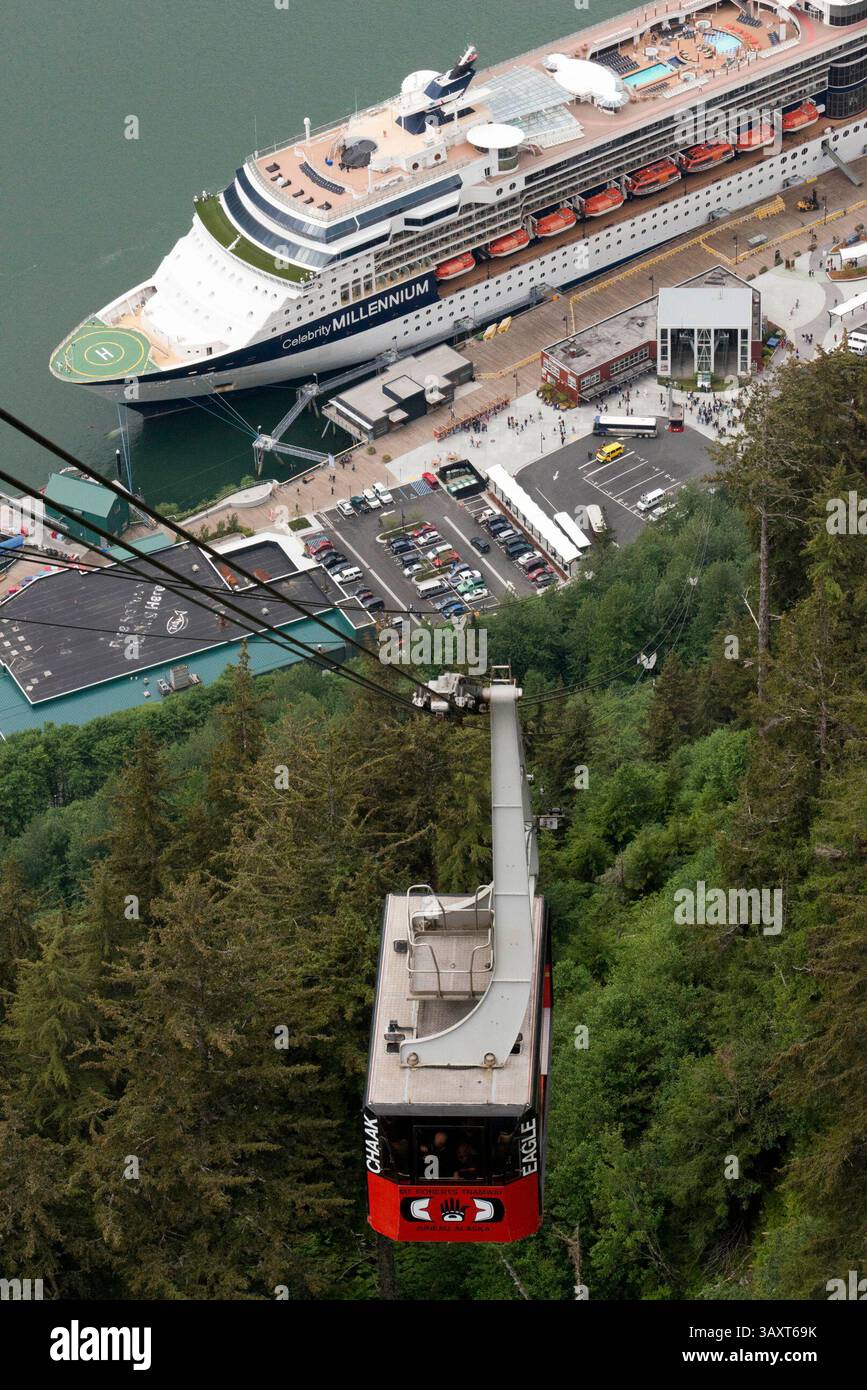 30 giugno 2016 - Juneau, Alaska, Stati Uniti - Juneau Downtown, City. Alaska. STATI UNITI. Celebrity Millennium, nave da crociera ormeggiata tra montagne innevate e la funivia del Monte Roberts al molo di Juneau, Alaska, Stati Uniti. Terminal delle navi da crociera e funivia del monte Roberts, Alaska, Inside Passage, Stati Uniti d'America. La funivia di Mount Roberts è una funivia aerea situata appena a sud del centro di Juneau, nello stato dell'Alaska. In funzione dal 1996, il tram effettua una salita di sei minuti del Monte Roberts da 3.819 piedi (1.164 m) dai moli delle navi da crociera (appena piedi sopra il livello del mare) a un'altezza di circa 1.800 piedi (55 Foto Stock
