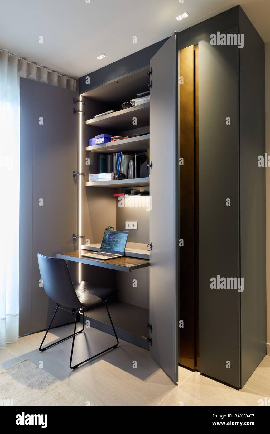 Un'idea funzionale con una piccola scrivania per lavorare in un guardaroba nero nella camera da letto di un giovane, design degli interni, Home, Paesi Baschi, Spagna Foto Stock