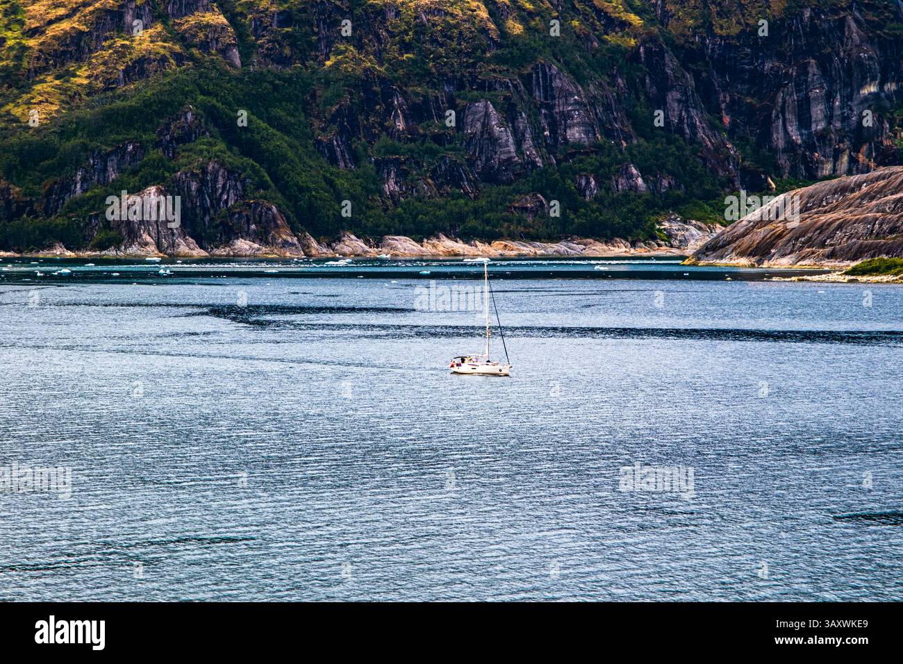 Canale di Beagle, Patagonia, Cile - 22 dicembre 2024: Una barca a vela passa davanti al braccio glaciale del canale di Beagle. Foto Stock