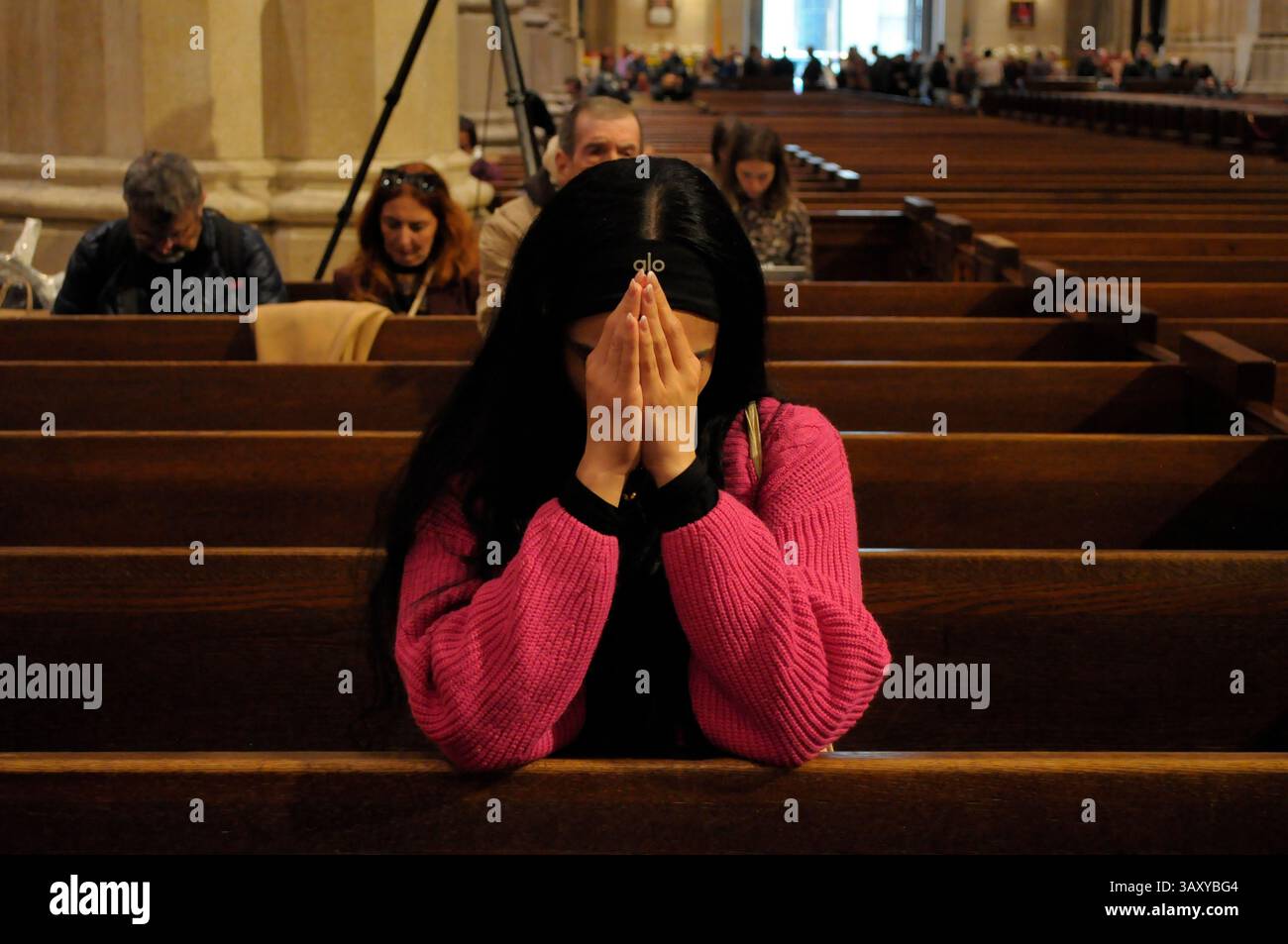 New York, Stati Uniti. 21 aprile 2025. Una persona prega nella cattedrale di San Patrizio. La cattedrale di San Patrizio ha tenuto una funzione commemorativa per Papa Francesco, morto lunedì 21 aprile all'età di 88 anni. I fedeli si riunirono nella cattedrale per rendere omaggio al defunto papa. La domenica di Pasqua, Papa Francesco ha salutato migliaia di fedeli in Piazza San Pietro. Il Vaticano ha detto che il papa è morto per un ictus che ha portato a coma e insufficienza cardiaca. Credito: SOPA Images Limited/Alamy Live News Foto Stock