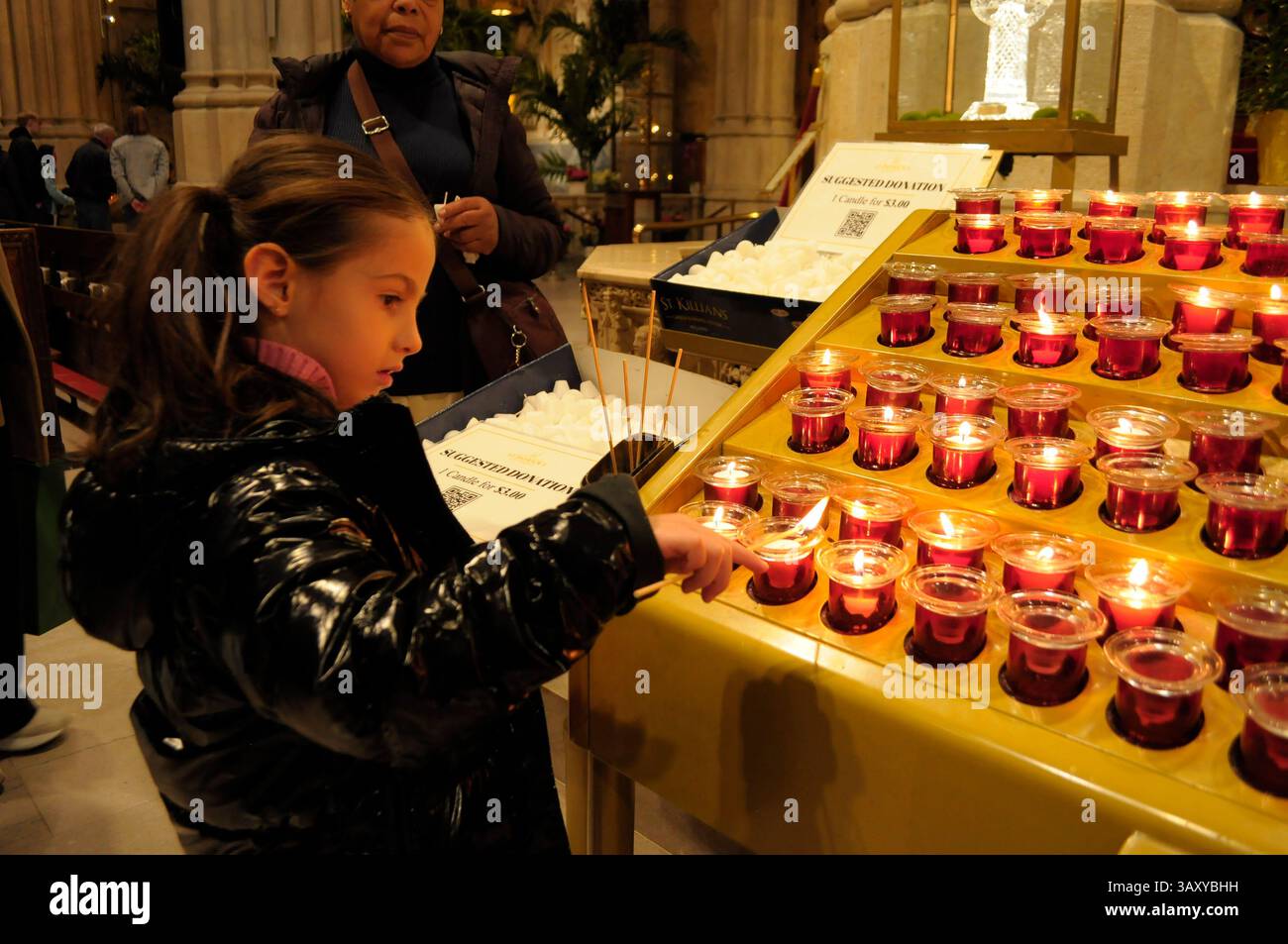 New York, Stati Uniti. 21 aprile 2025. Una persona accende una candela nella cattedrale di San Patrizio. La cattedrale di San Patrizio ha tenuto una funzione commemorativa per Papa Francesco, morto lunedì 21 aprile all'età di 88 anni. I fedeli si riunirono nella cattedrale per rendere omaggio al defunto papa. La domenica di Pasqua, Papa Francesco ha salutato migliaia di fedeli in Piazza San Pietro. Il Vaticano ha detto che il papa è morto per un ictus che ha portato a coma e insufficienza cardiaca. Credito: SOPA Images Limited/Alamy Live News Foto Stock