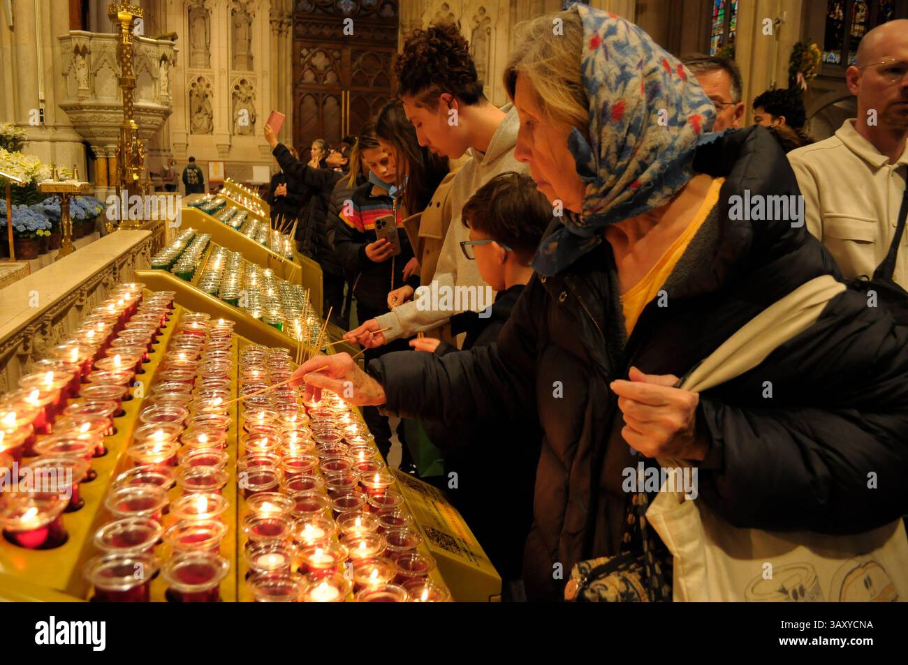 New York, Stati Uniti. 21 aprile 2025. La gente accende le candele nella cattedrale di San Patrizio. La cattedrale di San Patrizio ha tenuto una funzione commemorativa per Papa Francesco, morto lunedì 21 aprile all'età di 88 anni. I fedeli si riunirono nella cattedrale per rendere omaggio al defunto papa. La domenica di Pasqua, Papa Francesco ha salutato migliaia di fedeli in Piazza San Pietro. Il Vaticano ha detto che il papa è morto per un ictus che ha portato a coma e insufficienza cardiaca. (Foto di Jimin Kim/SOPA Images/Sipa USA) credito: SIPA USA/Alamy Live News Foto Stock