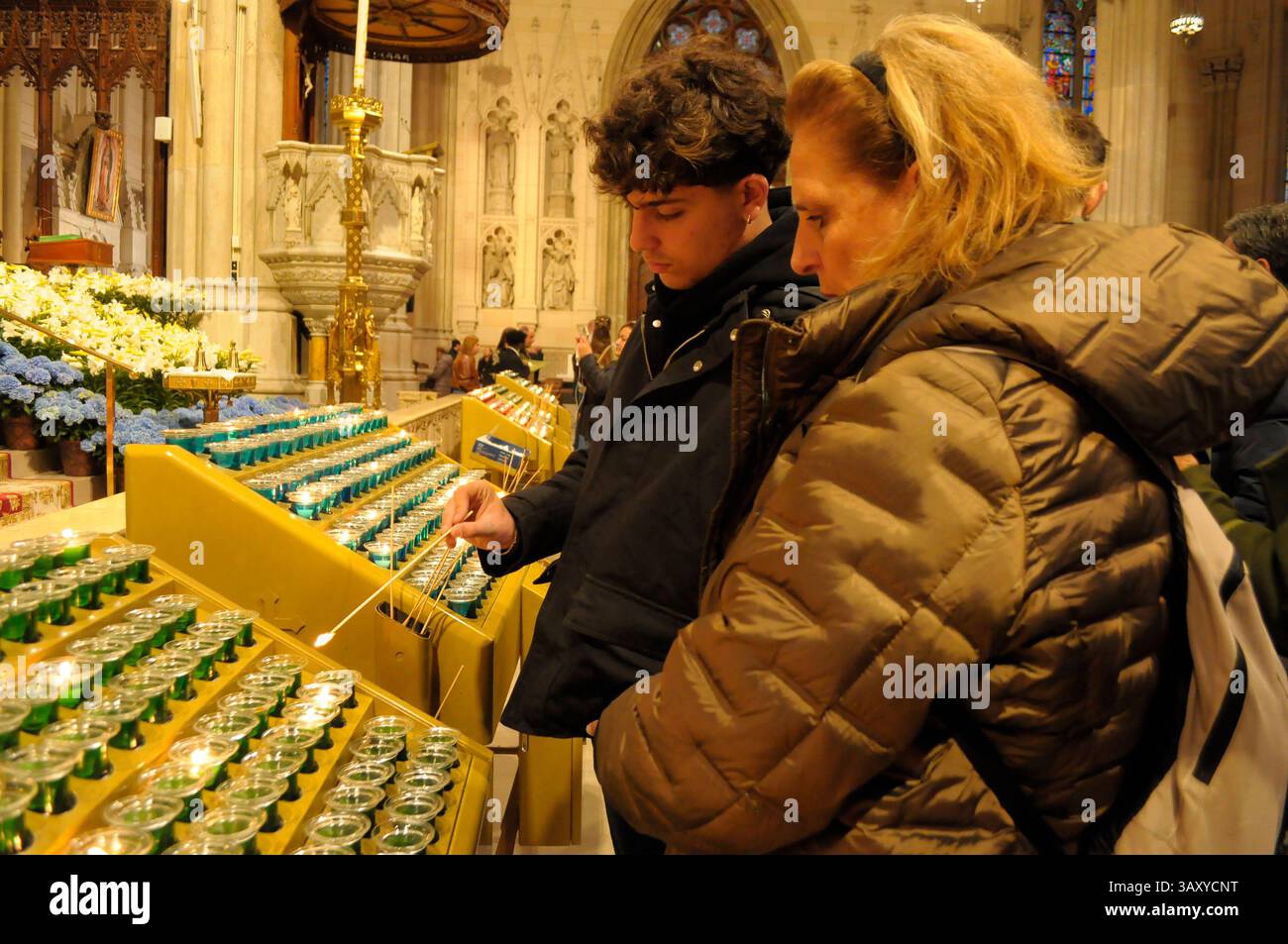 New York, Stati Uniti. 21 aprile 2025. La gente accende le candele nella cattedrale di San Patrizio. La cattedrale di San Patrizio ha tenuto una funzione commemorativa per Papa Francesco, morto lunedì 21 aprile all'età di 88 anni. I fedeli si riunirono nella cattedrale per rendere omaggio al defunto papa. La domenica di Pasqua, Papa Francesco ha salutato migliaia di fedeli in Piazza San Pietro. Il Vaticano ha detto che il papa è morto per un ictus che ha portato a coma e insufficienza cardiaca. (Foto di Jimin Kim/SOPA Images/Sipa USA) credito: SIPA USA/Alamy Live News Foto Stock