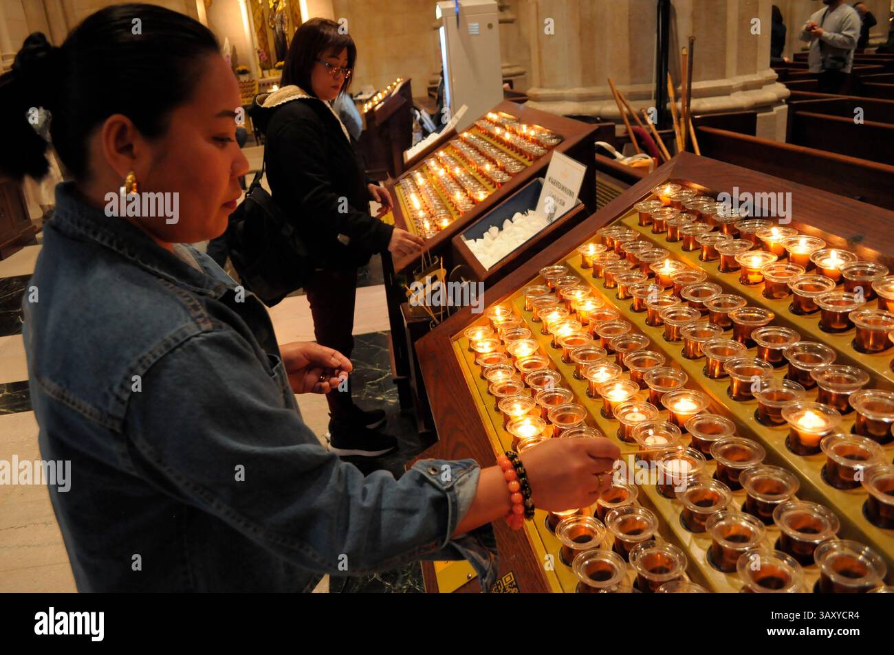 New York, Stati Uniti. 21 aprile 2025. La gente accende le candele nella cattedrale di San Patrizio. La cattedrale di San Patrizio ha tenuto una funzione commemorativa per Papa Francesco, morto lunedì 21 aprile all'età di 88 anni. I fedeli si riunirono nella cattedrale per rendere omaggio al defunto papa. La domenica di Pasqua, Papa Francesco ha salutato migliaia di fedeli in Piazza San Pietro. Il Vaticano ha detto che il papa è morto per un ictus che ha portato a coma e insufficienza cardiaca. (Foto di Jimin Kim/SOPA Images/Sipa USA) credito: SIPA USA/Alamy Live News Foto Stock