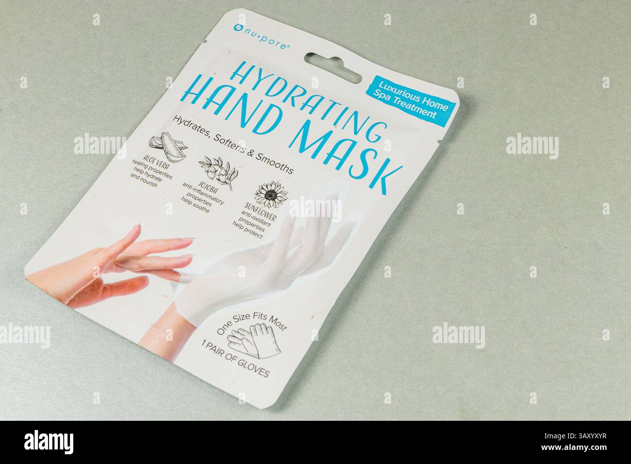 Leopoli Ucraina 10.04.25 Un pacchetto di una maschera idratante per le mani si trova su una superficie grigio chiaro, promuovendo l'idratazione della pelle, la morbidezza e la levigatezza per un luxuri Foto Stock