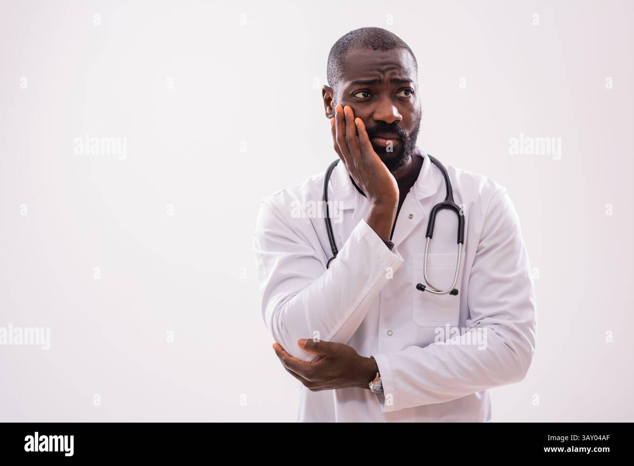 Ritratto di medico pensivo afroamericano in uniforme medica che è stanco e overworked. Foto Stock