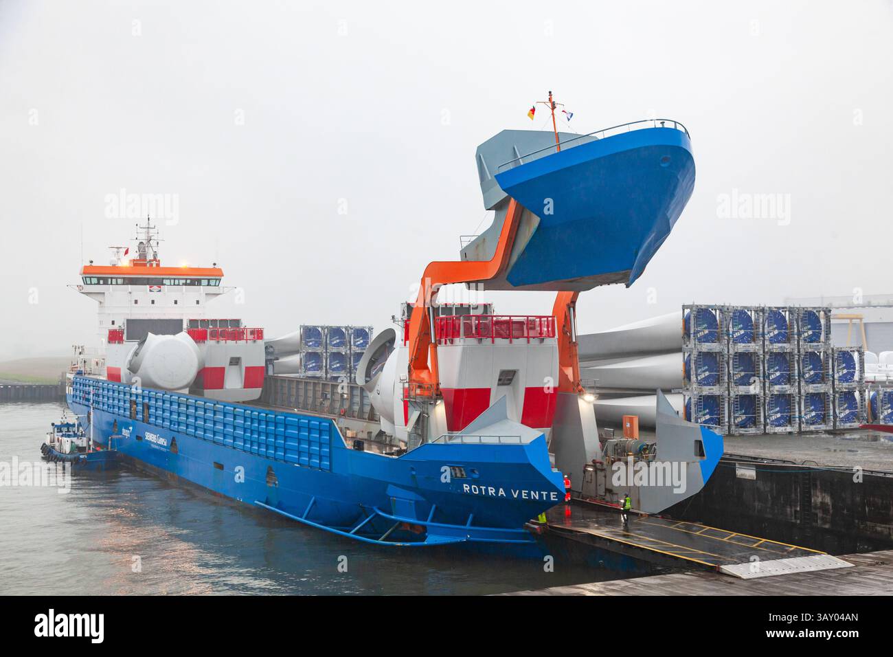Scaricando parti delle turbine eoliche Vestas nel porto di Cuxhaven, in Germania, da una nave da carico. Foto Stock