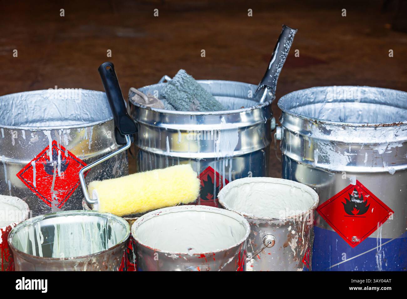 Secchi di vernice vuoti contenenti rulli e spazzole usati. Foto Stock