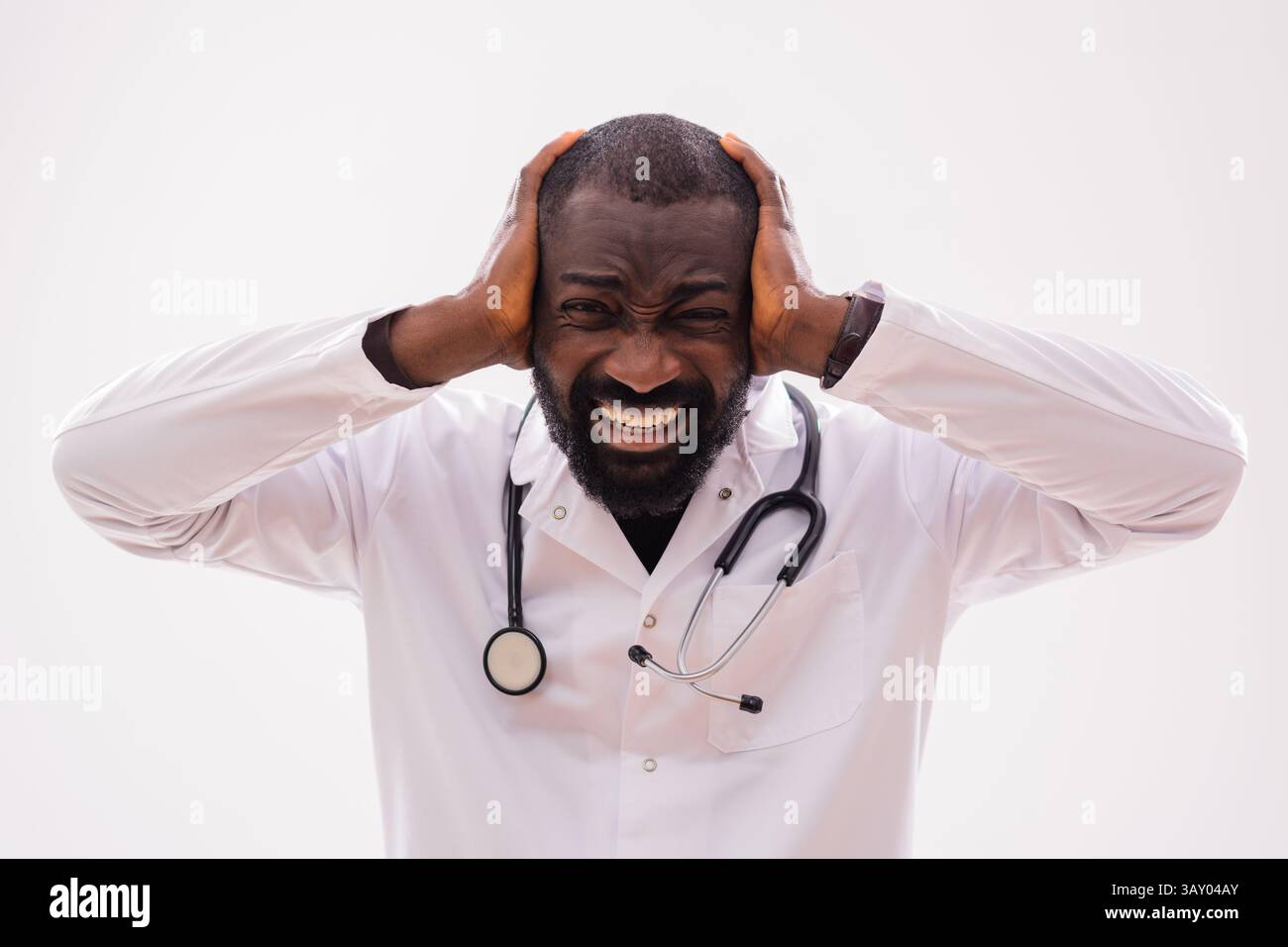 Ritratto di un paramedico ansioso uomo nero che sta affrontando stress e stanchezza. Studio girato su sfondo grigio. Foto Stock