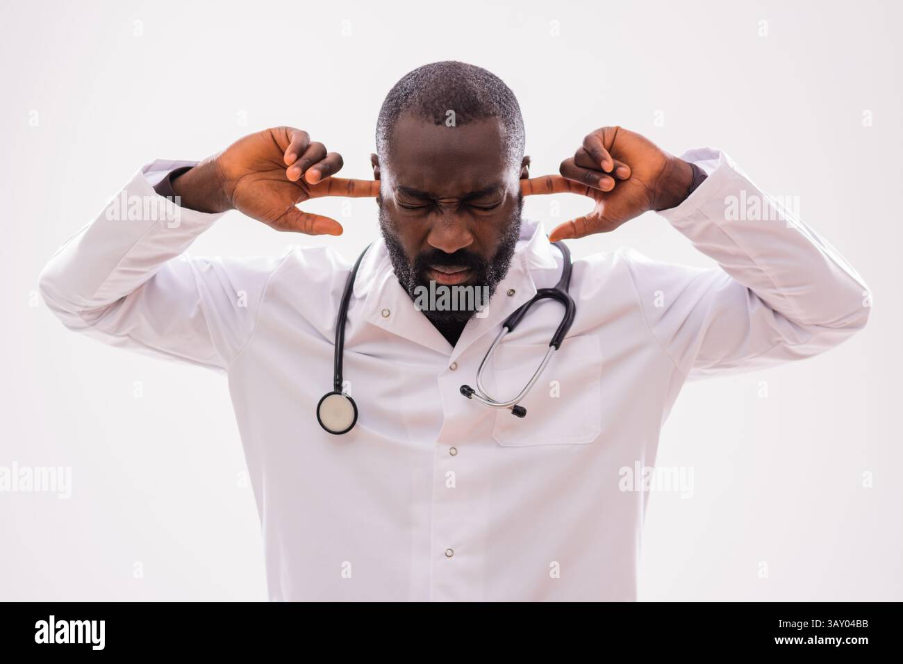 Ritratto di frustrato medico afroamericano in uniforme medica che si sente sovraccaricato dopo una lunga giornata di lavoro. Foto Stock