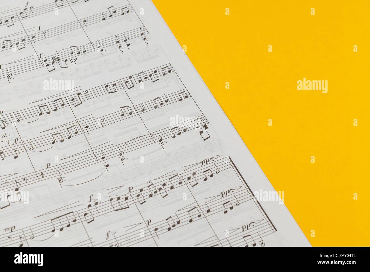 03.25.25 Leopoli Ucraina Una vista ravvicinata di spartiti che mostrano varie note musicali su uno sfondo giallo brillante, perfetto per ispirare creatività e Foto Stock