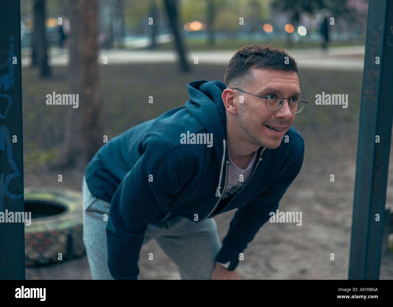 Un ragazzo fa pull-up su un terreno sportivo per mantenere una buona salute Foto Stock