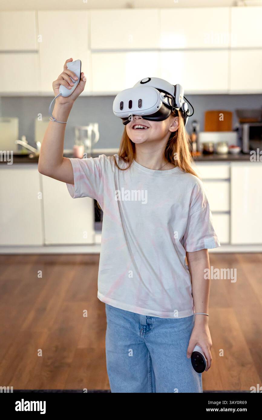 Ragazza con occhiali VR che gioca a casa. Imparare e giocare con gli occhiali per la realtà aumentata. Tecnologia e sviluppo Foto Stock