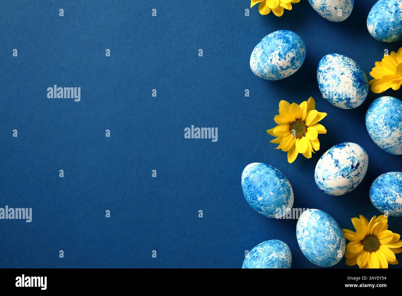 Sfondo blu scuro con uova di Pasqua e fiori gialli, spazio per testo e saluti Foto Stock