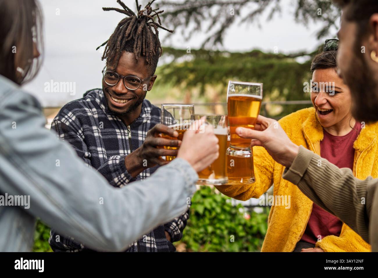 Gruppo di amici allegri che festeggiano insieme con bicchieri da birra all'aperto, sorridendo e godendosi un momento informale di connessione e divertimento in natura Foto Stock Gruppo di amici allegri che festeggiano insieme con bicchieri da birra all'aperto, sorridendo e godendosi un momento informale di connessione e divertimento in natura Foto Stock